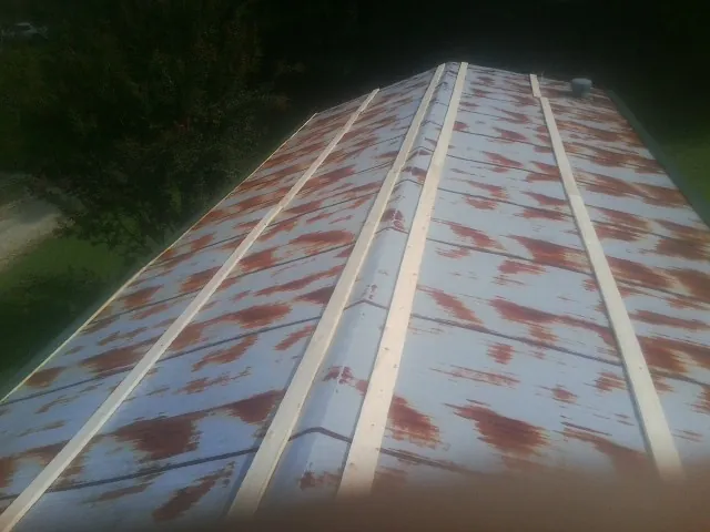Rusted metal roof panels with new wood purlins before replacement — Storm Damage Roof Repair in Monitor by Roofing Brothers