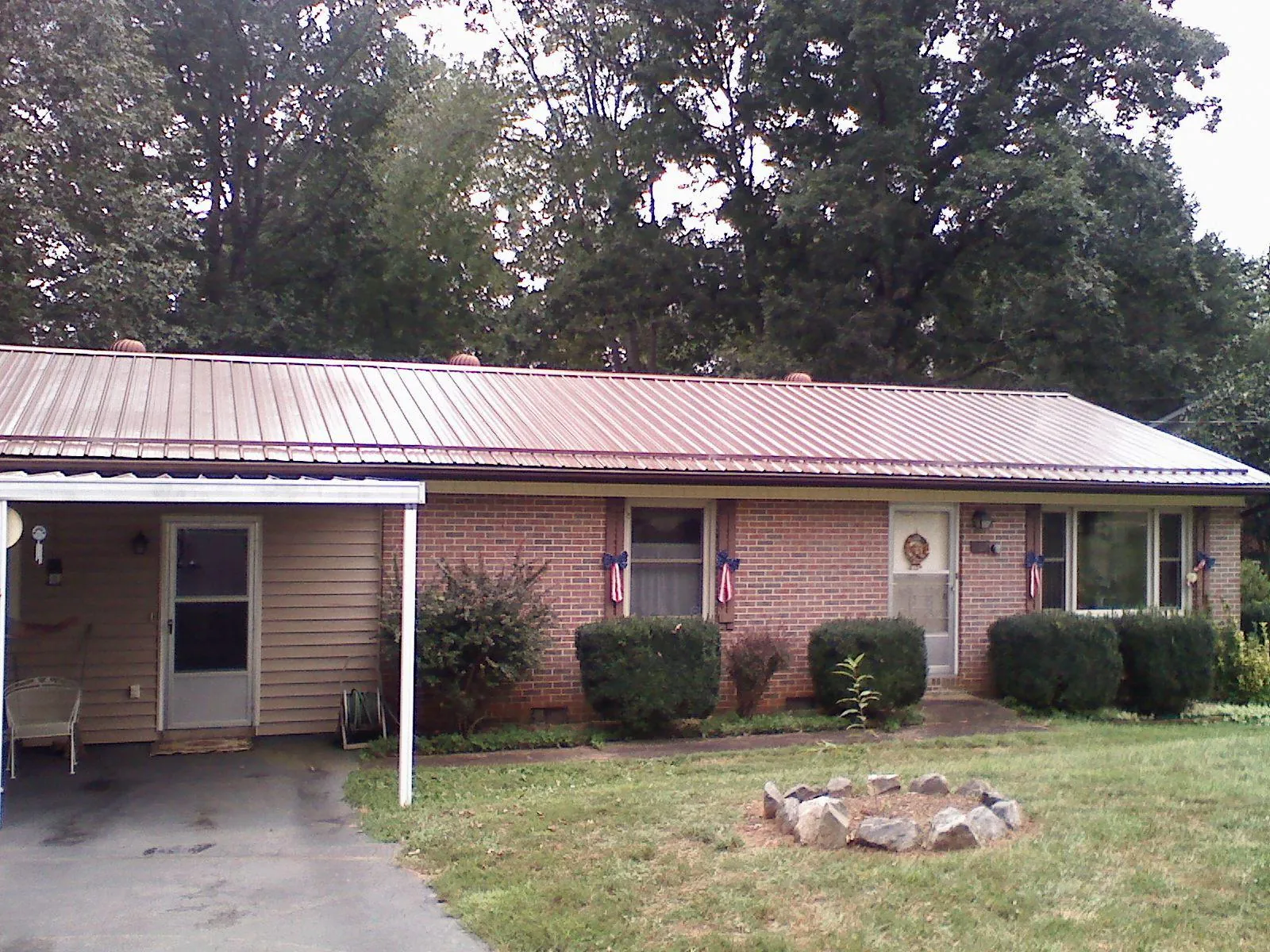Bronze metal roof and carport on a brick ranch home — Roof Repair work by our crew in Monitor
